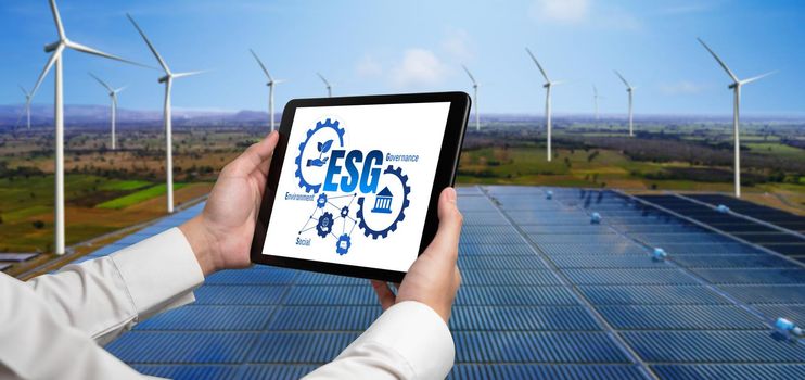 Green business transformation for environment saving and ESG business concept. Businessman using tablet to set corporate goal toward environmental friendly management and alternative clean energy use.