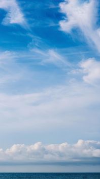 VERTICAL PANORAMA real photo natural cloudscape wallpaper. Beautiful white fluffy cumulus clouds summer blue sky calm sea horizon skyline. Concept relax mood, more size and tone collection in stock.