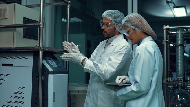Two scientist in professional uniform working in laboratory for chemical and biomedical experiment