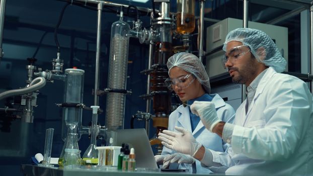 Two scientist in professional uniform working in laboratory for chemical and biomedical experiment