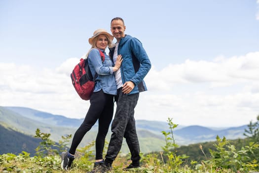 Portrait of beautiful young couple enjoying nature at mountain peak