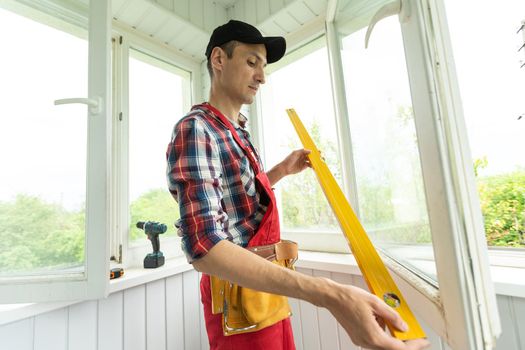 Man measuring window prior to installation of roller shutter outdoors