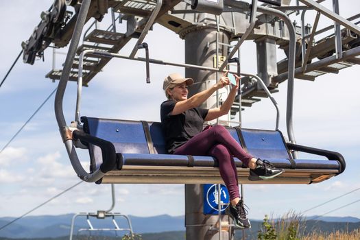vacation in Carpathian mountains. woman on the lift in the mountains in summer. Ukrainian ski lift transportation