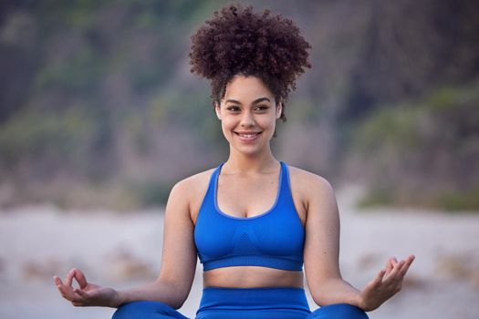 Yoga is invigoration in relaxation. Freedom in routine. a young female doing yoga on the beach