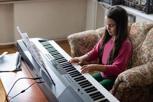 little girl playing on a new synthesizer in the old room.