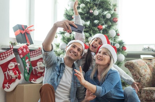 family having fun and playing together near Christmas tree indoors