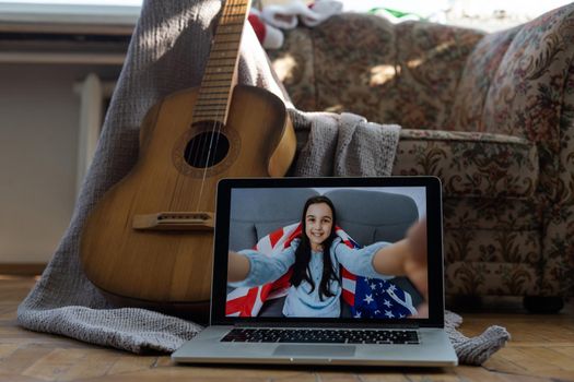 little girl having guitar lesson online at home.