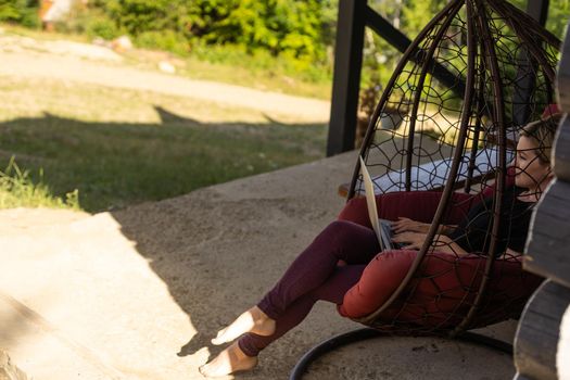 Woman working on computer outdoor with mountain view