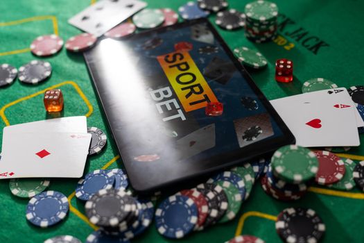 Smartphone with poket table on scree, playing cards and chip cards on poker table. Online casino.