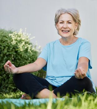 Yoga made me a happy old lady. a senior woman doing yoga outside in her yard