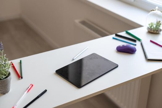 tablet putting on wooden working desk with pencil and pen.