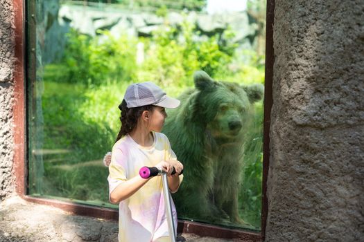 little girl on a scooter at the zoo