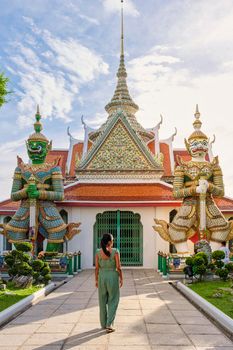 Wat Arun temple Bangkok Thailand, Temple of Dawn, Buddhist temple alongside Chao Phraya River.Beautiful Wat Arun at dusk evening sunset, Asian woman visiting temple