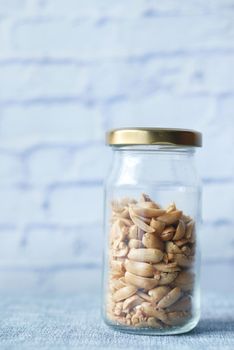 peanuts in a glass jar on table .