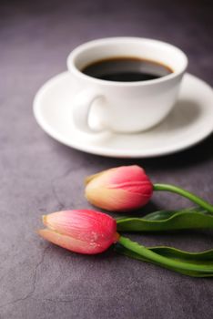 pink tulip and coffee cup on black background ,