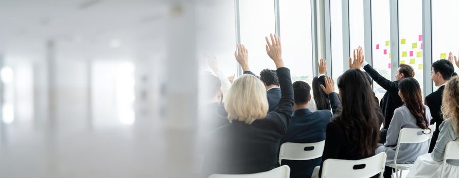 Group of business people meeting in a seminar conference widen view . Audience listening to instructor in employee education training session . Office worker community summit forum with speaker .