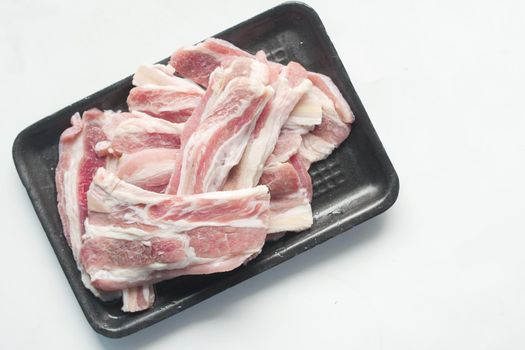 Raw fed bacon strips on white background ,