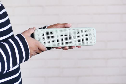 man's hand using smart speaker on table .