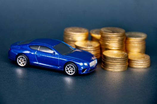 Kuala Lumpur, Malaysia - July 2022 : Miniature toy car of Bentley Continental GT with gold coins on black cover background. Copy space.