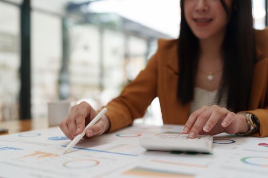 Attractive Asian business woman working with a laptop to audit financial at office. Account concept