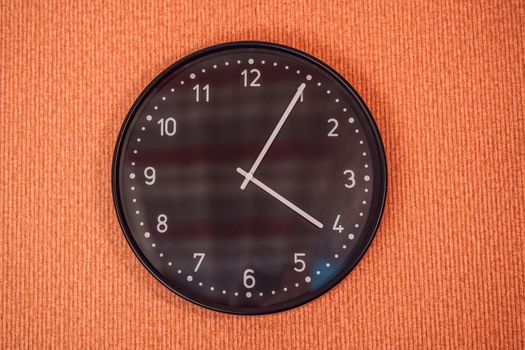 Classic black and white analog clock on red background at One o'clock with copy space.