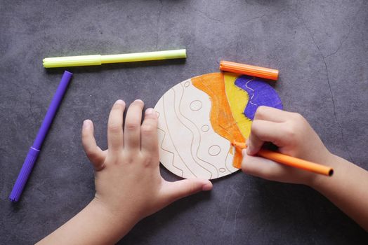 child girl drawing on paper sitting on floor .