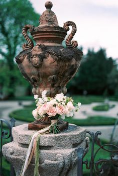 Bouquet of flowers lies near an antique vase in the garden. Lake Como, Italy. High quality photo