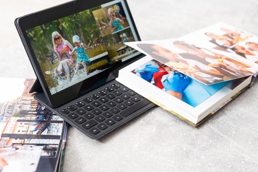 technology, age, memories and people concept. photobook album and tablet on the table.