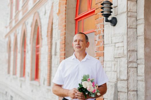 a man groom with a bouquet of flowers. photo