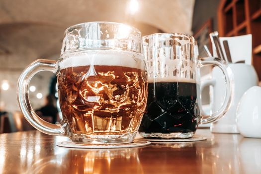 Two mugs of white and dark beer in pub. High quality photo