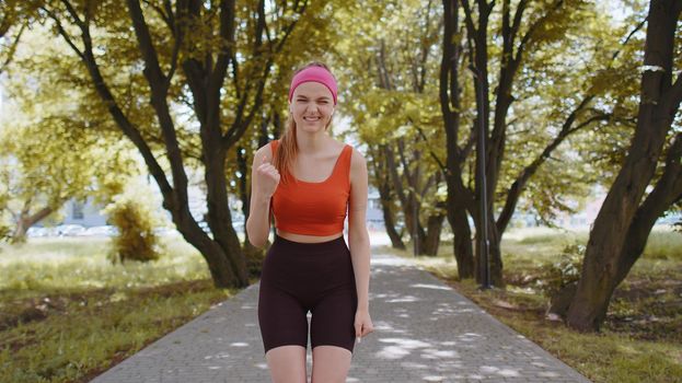 Athletic fit runner girl celebrate success win scream rejoices triumph victory marathon race. Workout cardio training in sunny park. Young woman enjoy healthy lifestyle. Active sportswoman motivation