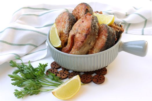 Deep-fried red fish with a delicious crust. Fried fish snacks in a frying pan. Pieces of Keta fish fried in boiling oil.