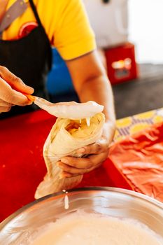 Hands making a Nicaraguan quesillo. Close up of hands making a traditional quesillo with pickled onion. Preparation of Nicaraguan quesillo, traditional Central American food quesillo