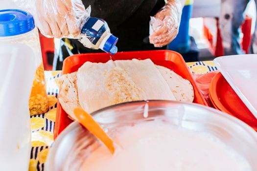 Close up of hands making a traditional quesillo with pickled onion. Preparation of Nicaraguan QUESILLO, traditional Central American food quesillo. Hands making a Nicaraguan quesillo