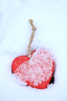 Red wooden heart shaped ornaments in fresh fallen snow