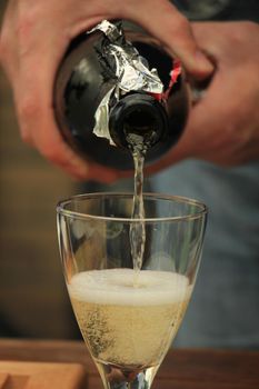 Man pouring white wine at a dinner table