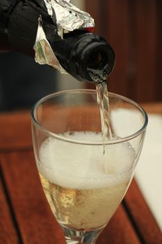 Man pouring white wine at a dinner table