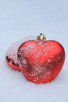 Red heart shaped ornaments in fresh fallen snow