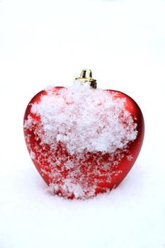 Red heart shaped ornament in fresh fallen snow