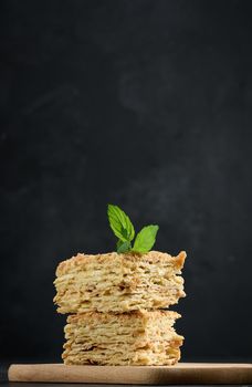 A stack of baked Napoleon pie slices with cream. Puff pastry, delicious dessert