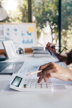 Business woman calculating domestic expenses involved in financial paperwork indoors, focused lady managing monthly banking payments summarizing utility bills and taxes at home.