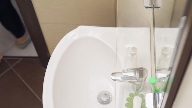 Washbasin In Home Bathroom, Chrome Faucet And White Ceramic Sink With Mirror Hanging On The Wall In Cozy Washroom, High Angle View