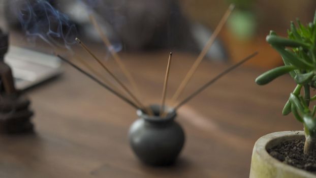 Business Work Place, Ethnic And Religious Items, Close Up Of Incense Sticks Stands On Wooden Table With Other Objects Of Faith And Meditation