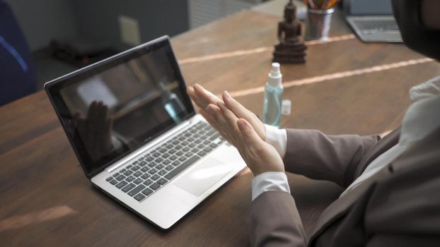 Business Woman Applies Disinfectant Spray To Disinfect Her Hands Before Working On Laptop, Preventive Measures For Disinfection When Working With Computer During Coronavirus Epidemic, High Angle View