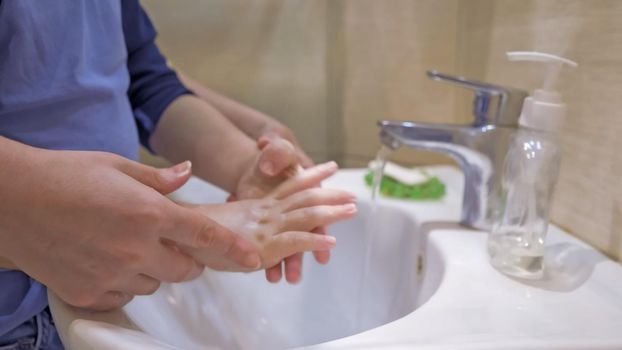 Washing Hands With Mom, Close Up Of Women's Hands Helping The Kid Wash The Soap Well, Boy Soaping Hands And Mom Helps Him Clean His Hands Directing Under Stream Of Water