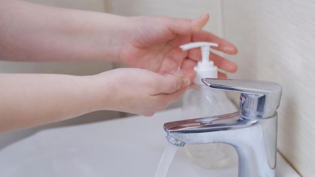 Female Hands Demonstrate Hygiene Rules During An Epidemic Of A Coronavirus, Caucasian Woman Washing Her Hands With Antibacterial Soap, Side View, Close Up Shot