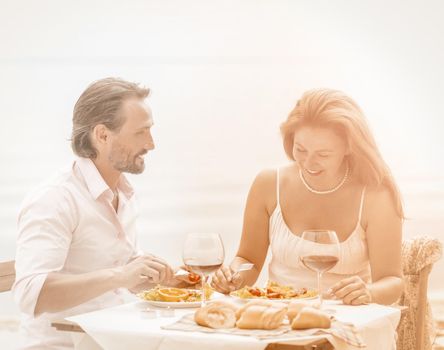 Couple dating dinner. Happy lovers on table in restaurant.