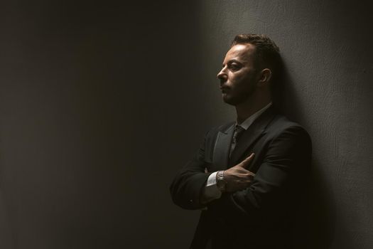 Sad man in black suit on black background. Depression concept. Black background. People after pandemic lifestyle concept. Dark background.