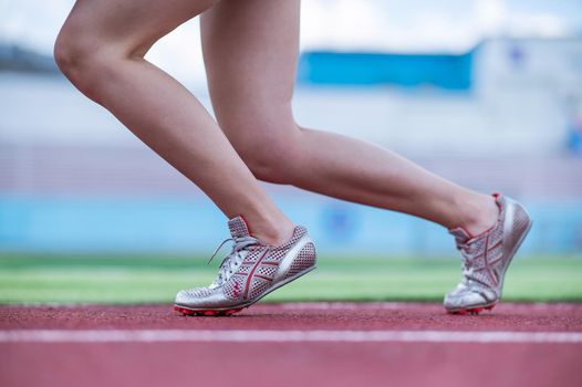 Close-up of female legs. The runner in the stadium