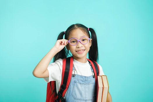 Close-up kid students girl smiling holding book, going to school. school concept.